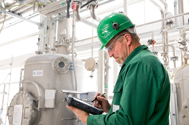 Industrii - Datele din fabrică surprind un bărbat cu pălărie verde folosind o tabletă
