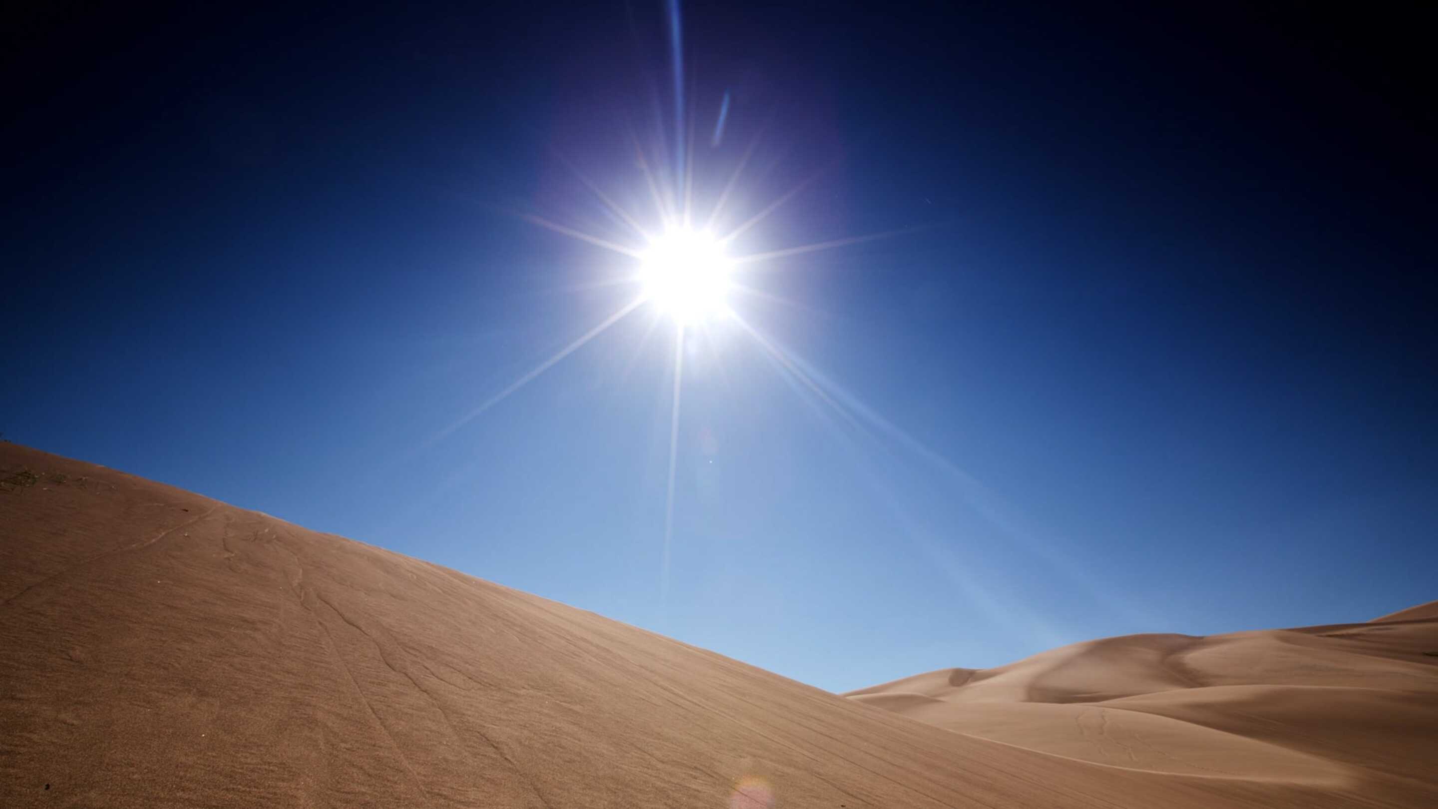 Uitgebreid temperatuuraanraakscherm, een zon die over een zanderige heuvel schijnt