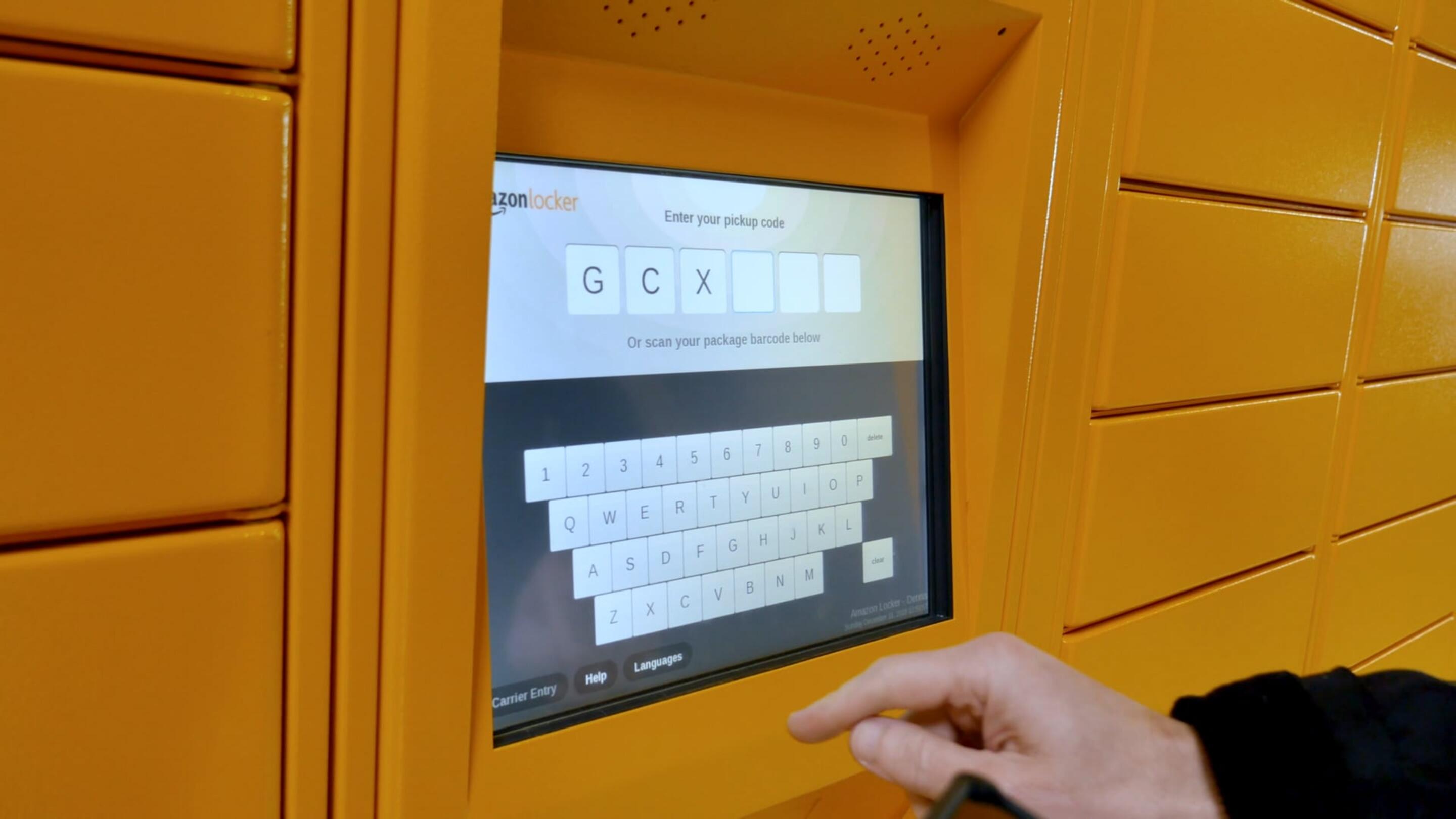 IK10 Monitor - IK10 Monitor Touchscreen Pakketstation een hand wat betreft een toetsenbord op een gele machine