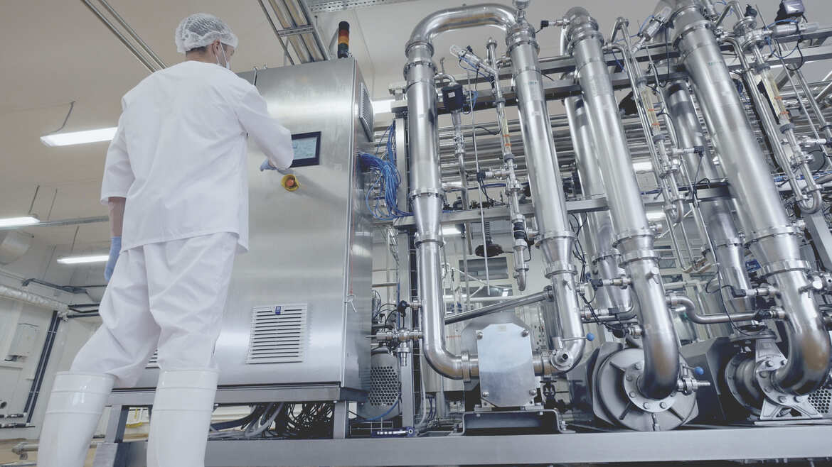 Les écrans tactiles comme interface utilisateur dans l'industrie agro-alimentaire un homme en robe blanche et gants blancs travaillant dans une usine
